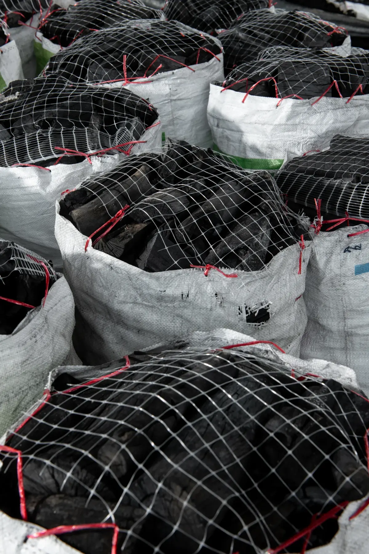 Hardwood lump charcoal bagged in netted sacks