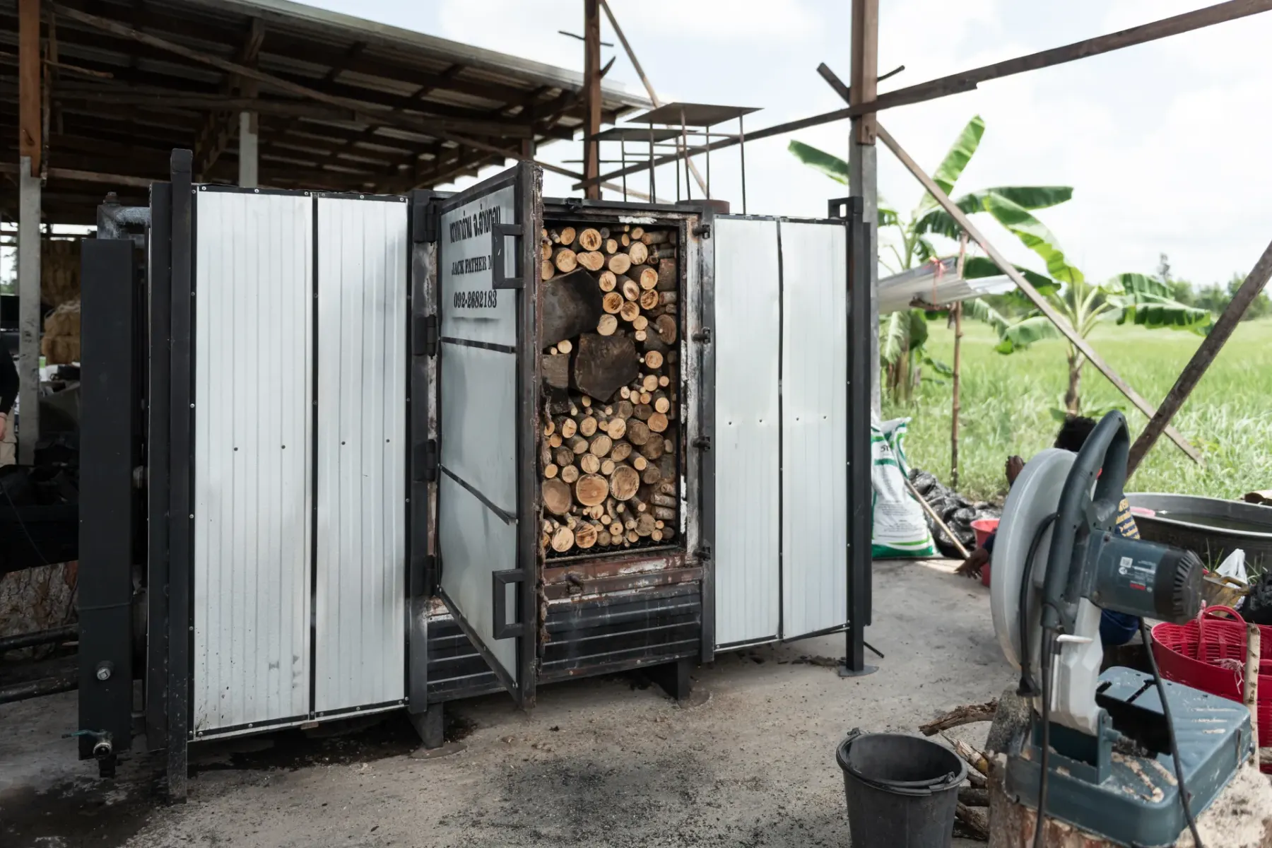 Steel kiln loaded with hardwood, door open