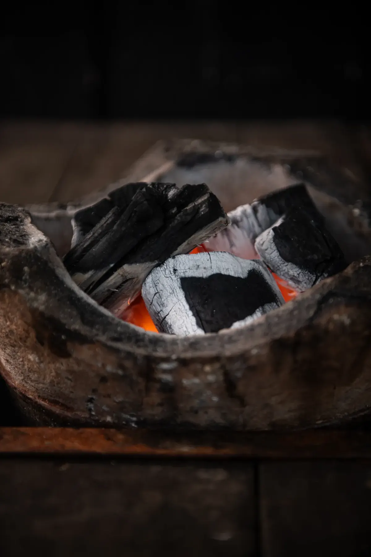 Hardwood lump charcoal burning in a clay stove